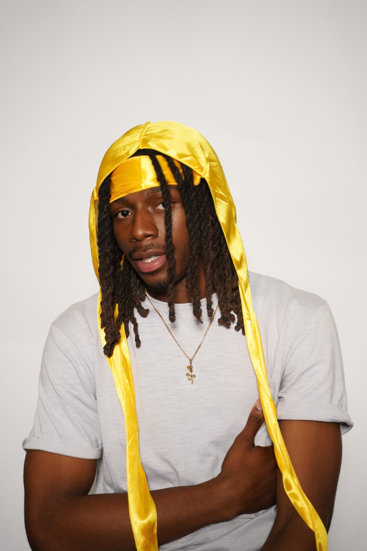 Model with locs pulled through the yellow Elite Wrap band, ties draped over the shoulders