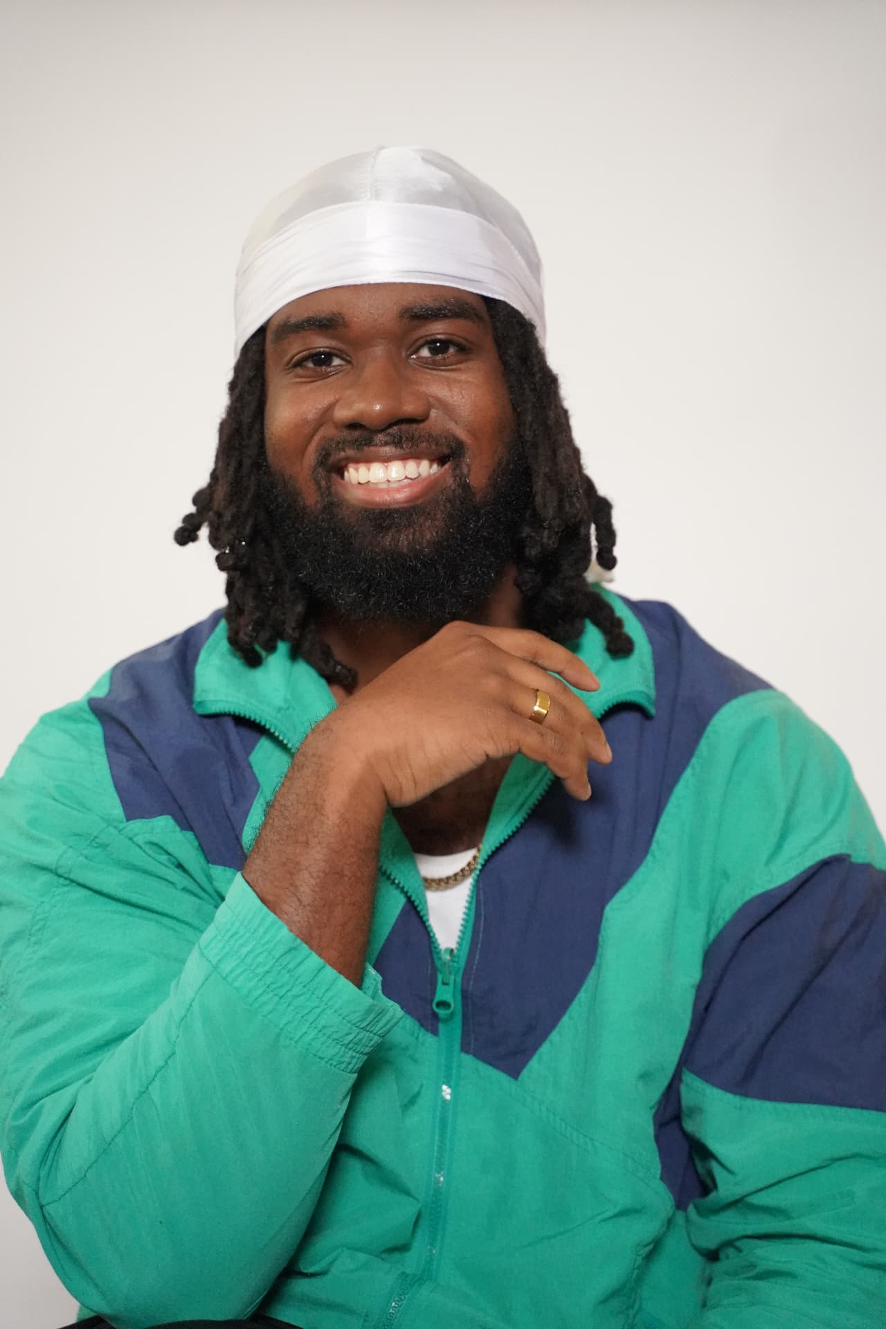 Smiling model with locs wearing the white Elite Wrap tied at the front
