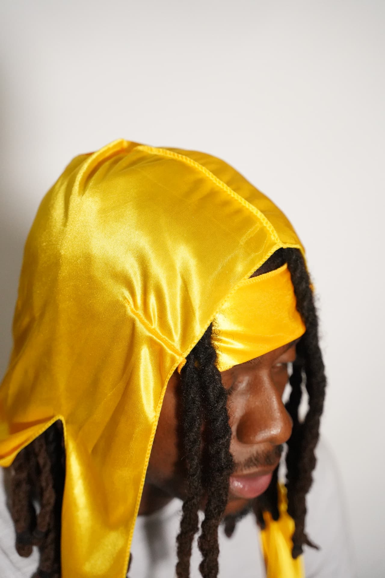 Close-up side view of the yellow Elite Wrap showing the integrated flap over locs